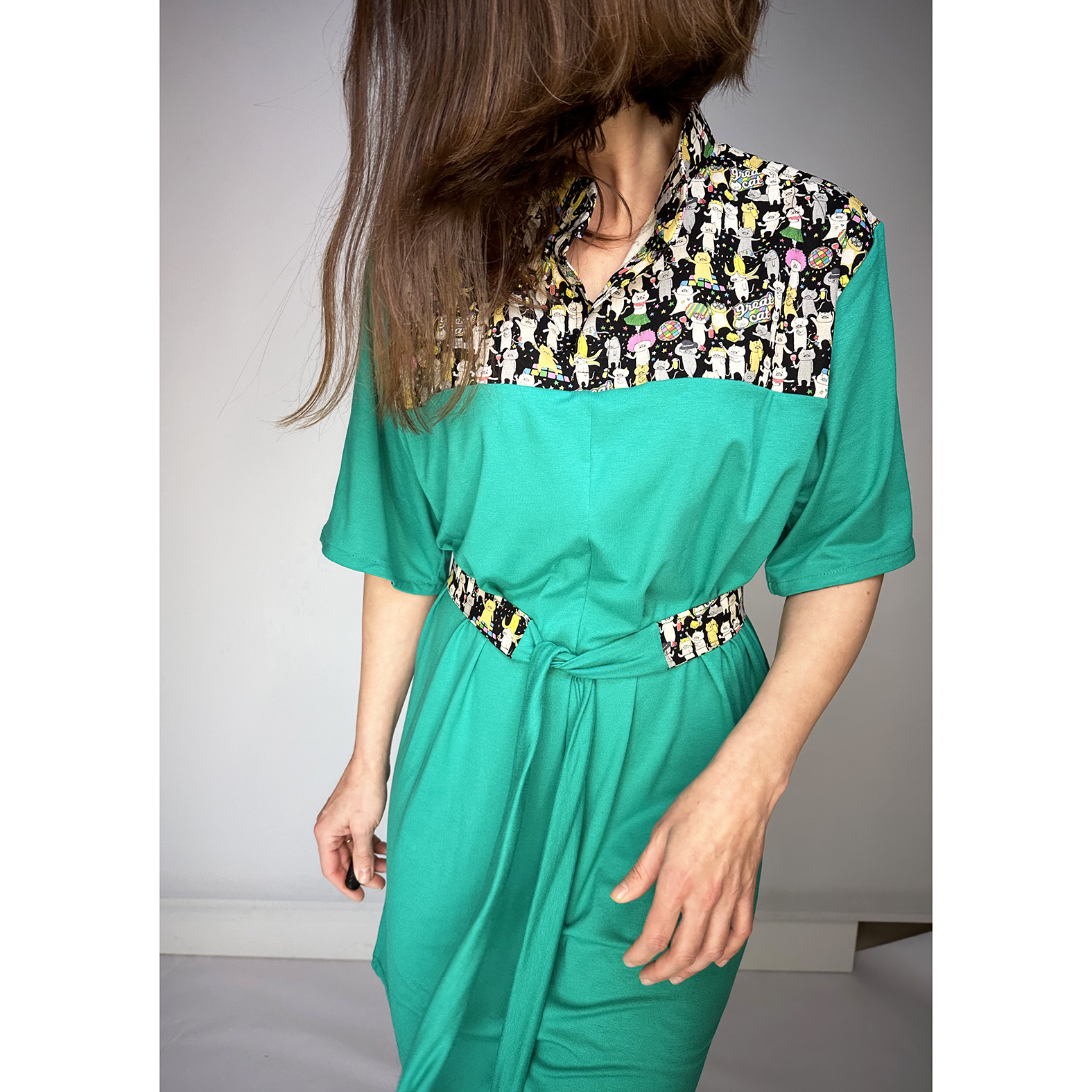 Discover our stunning Flowy Green Dress adorned with playful Japanese Party Cats! Flowy Green Dress with Japanese Party Cats Print: Features a versatile sash for customizable shaping, chic half sleeves with black cotton bias tape, and a comfortable fit crafted from a luxurious blend of 96% viscose and 4% elastane jersey fabric. Unique design highlights shoulders, collar, and belt crafted from exquisite Japanese cotton printed fabric. Meticulously designed and handmade in Studio Catta Amsterdam. FREE NL shipping & €12 worldwide shipping.