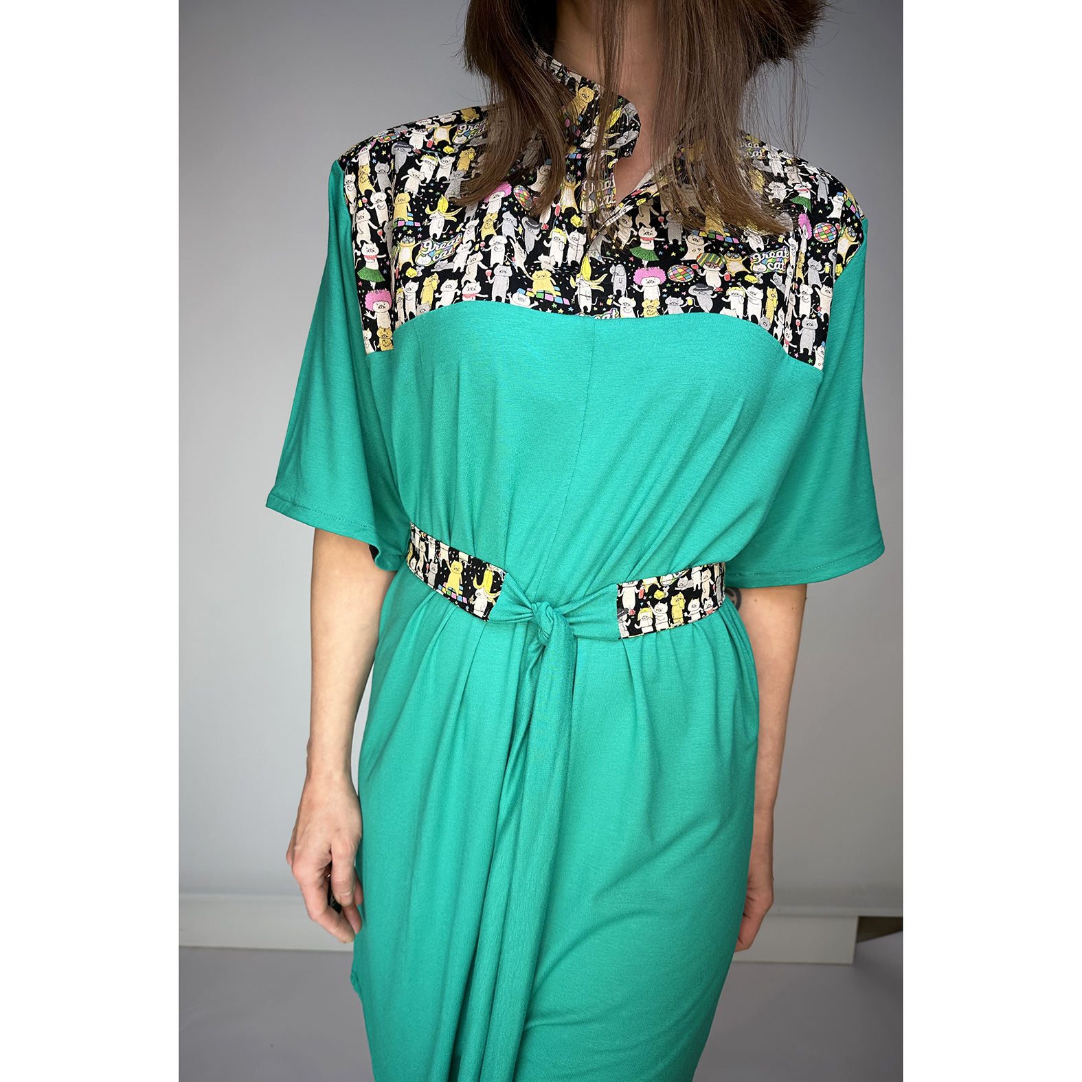 Discover our stunning Flowy Green Dress adorned with playful Japanese Party Cats! Flowy Green Dress with Japanese Party Cats Print: Features a versatile sash for customizable shaping, chic half sleeves with black cotton bias tape, and a comfortable fit crafted from a luxurious blend of 96% viscose and 4% elastane jersey fabric. Unique design highlights shoulders, collar, and belt crafted from exquisite Japanese cotton printed fabric. Meticulously designed and handmade in Studio Catta Amsterdam. FREE NL shipping & €12 worldwide shipping.