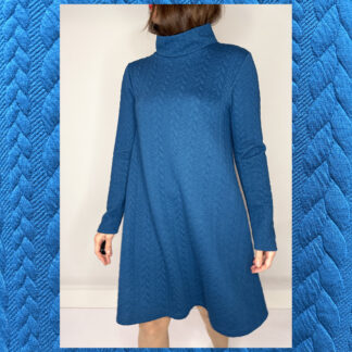A teal turquoise cable knit A-line dress with a cozy turtleneck and long sleeves, handmade by Studio Catta Amsterdam Slowfashion