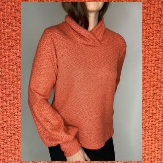 Handmade sustainable sweater by Studio Catta with a crossover turtleneck, puffed sleeves, and a coral and grey mélange design.