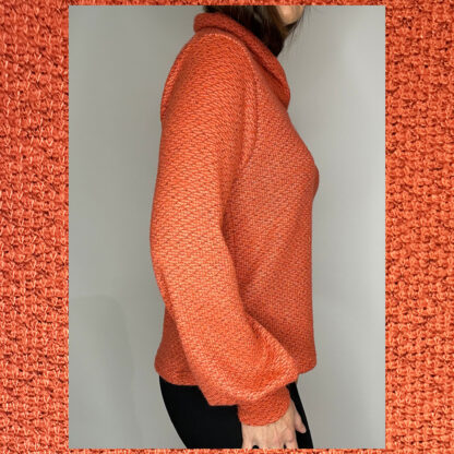 Handmade sustainable sweater by Studio Catta with a crossover turtleneck, puffed sleeves, and a coral and grey mélange design.