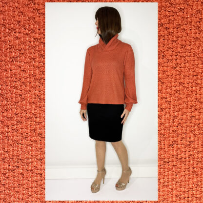 Handmade sustainable sweater by Studio Catta with a crossover turtleneck, puffed sleeves, and a coral and grey mélange design.