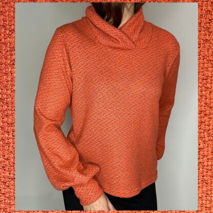 Handmade sustainable sweater by Studio Catta with a crossover turtleneck, puffed sleeves, and a coral and grey mélange design.
