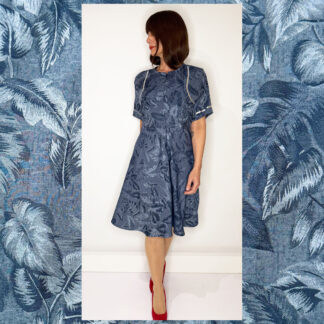 Blue fitted dress with palm tree jacquard, elbow-length sleeves, front invisible zipper, and an A-line skirt to the knee, made from woven viscose blend with silver print details; handmade by Studio Catta.