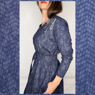 Blue Relief Dress with long sleeves, adjustable belt, side pockets, and silver thread shoulder prints, made in Studio Catta Amsterdam